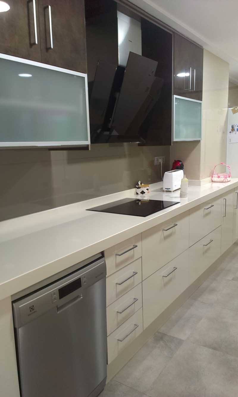 Cocina en tonos oscuros con muebles a medida y campana extractora negra